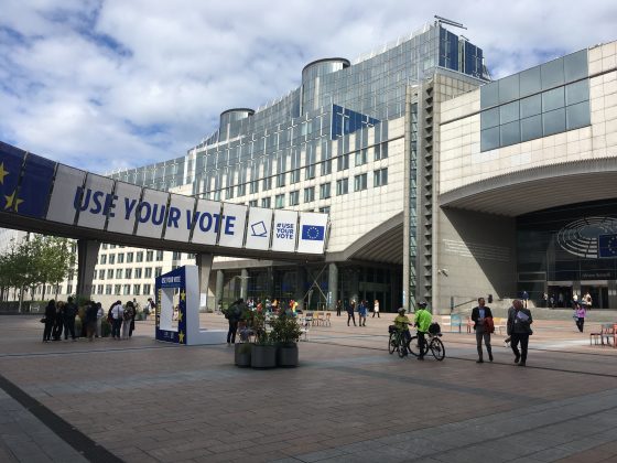 Photo of European Commission buildings with poster of "Use Your Vote" on a bridge