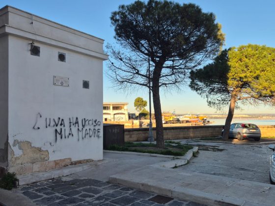 Picture of building with graffiti saying "ILVA killed my mother" in Italian